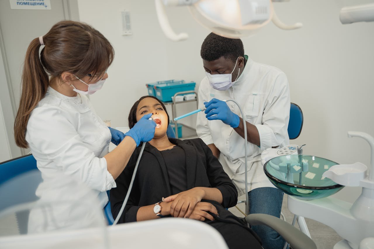 our-experience Dentists providing care to a patient in a clean, modern dental clinic.